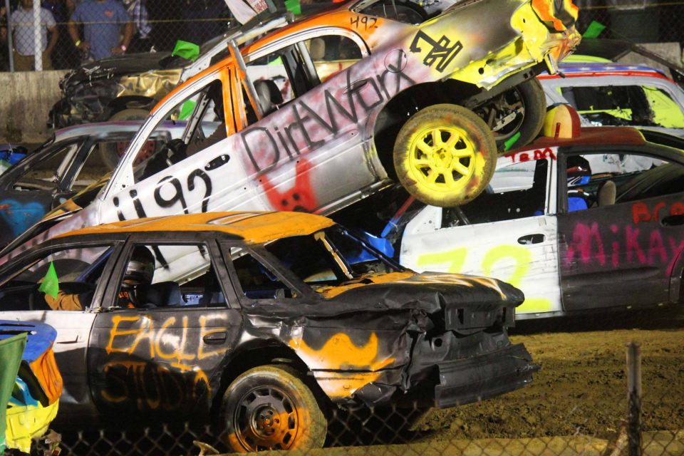 Car flying through the air as part of a demolition derby competition.
